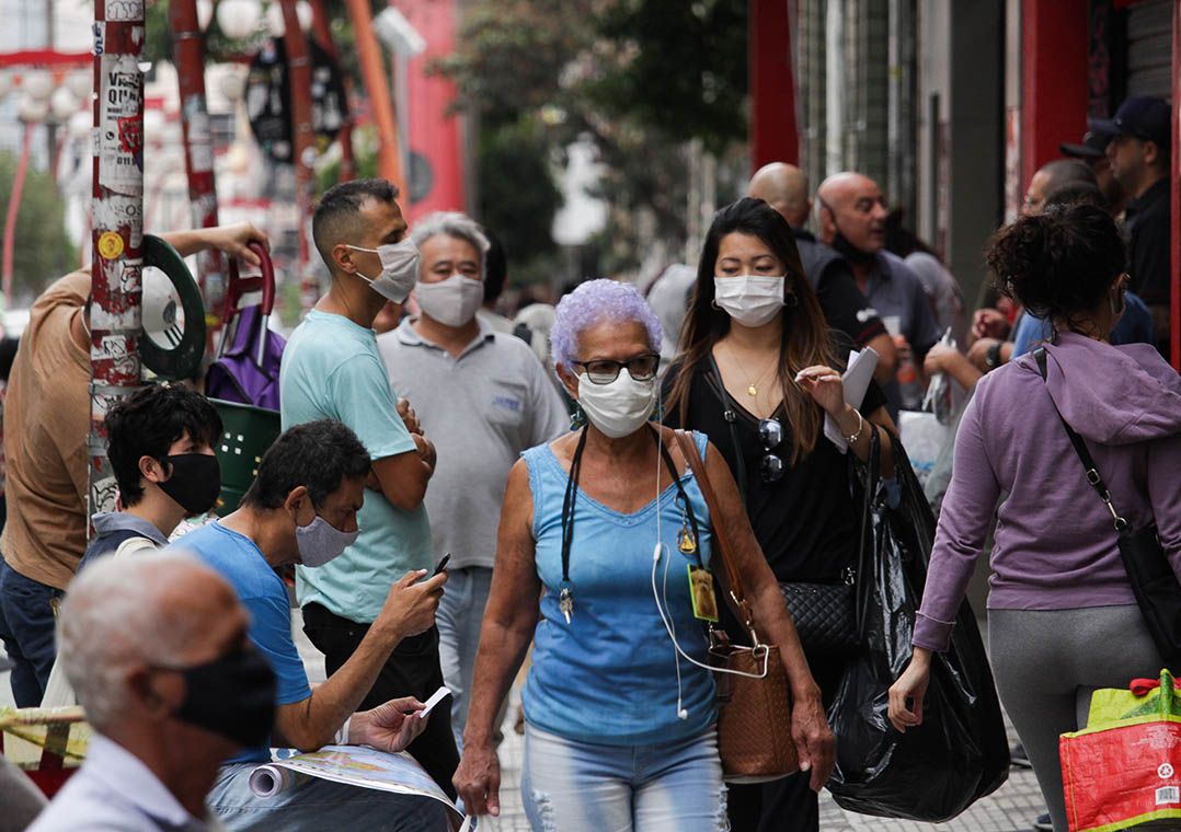 Pessoas usam máscaras de proteção em prevenção à covid-19 enquanto circulam pelo bairro da Liberdade, no centro da cidade de São Paulo